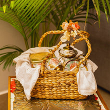Load image into Gallery viewer, A wicker gift hamper basket filled with various goodies and wrapped with a bow