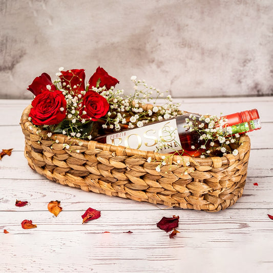 Handcrafted wicker oval tray on a wooden table adorned with fruit and flowers