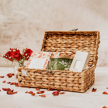 Load image into Gallery viewer, Image of a wicker trunk basket with a sturdy lid, metal hinges, and clasp. The box has a natural woven texture and is perfect for storing accessories or as a gift box
