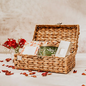 Image of a wicker trunk basket with a sturdy lid, metal hinges, and clasp. The box has a natural woven texture and is perfect for storing accessories or as a gift box